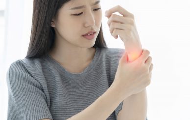 unhappy asian woman hand touch wrist with hand hurt from work or exercise white background