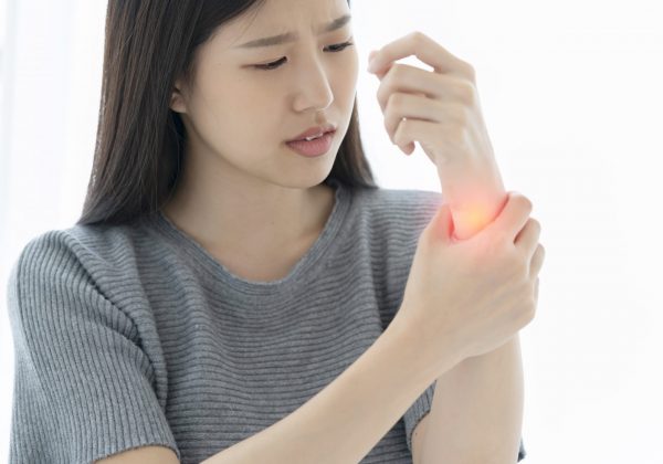 unhappy asian woman hand touch wrist with hand hurt from work or exercise white background